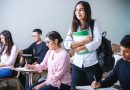 woman carrying white and green textbook